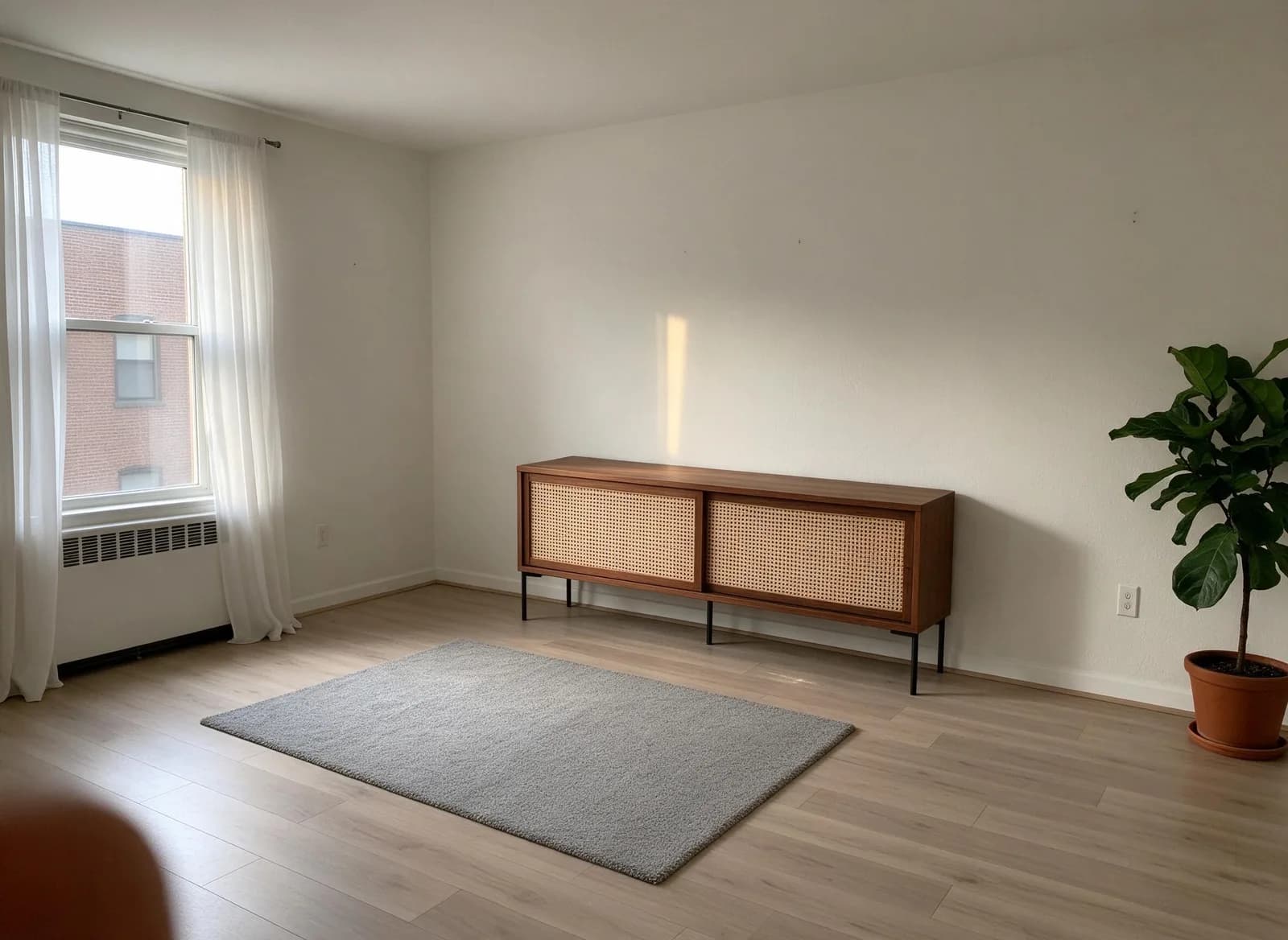 The demo living room with only the rattan sideboard placed against the wall